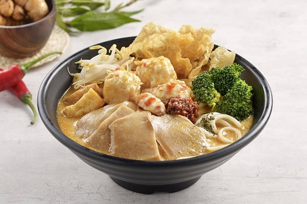 a bowl of creamy ramen with vegan chicken and broccoli from green dot vegetarian 