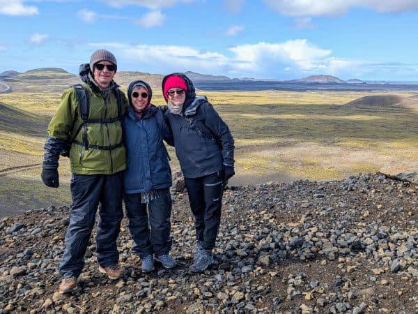 three travelers posed on top of a mountain in iceland