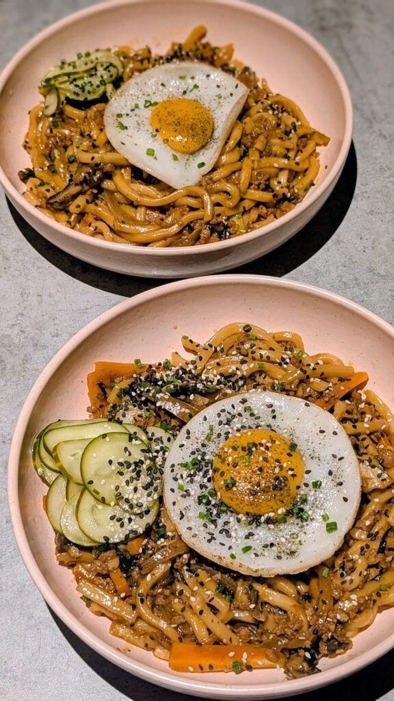 two large bowls of vegan noodles topped with a vegan egg at the kind kitchen in porto