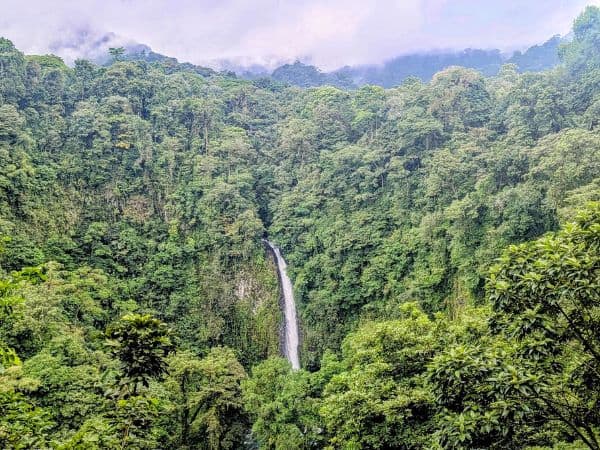 the la fortuna waterfall tucked in the jungle from high above in costa rica