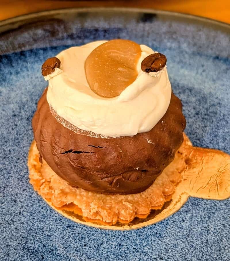 small round vegan chocolate coffee cake topped with cream and caramel at my green pastry in porto