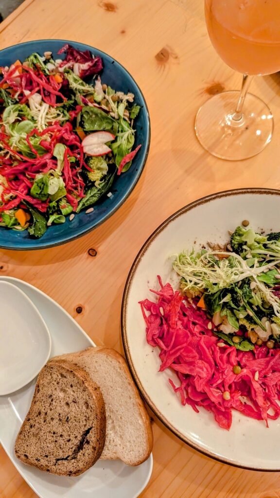 two colorful salads next to two slices of bread at sete in coimbra