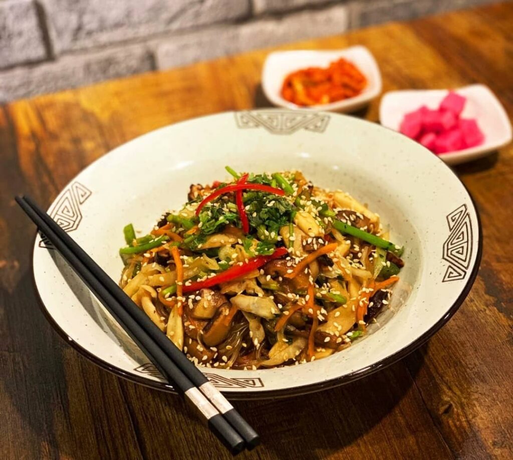 a large bowl of spicy japche with sweet potato noodles at chopsticks at the boneless kitchen in singapore