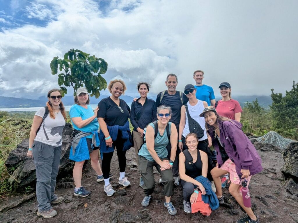 veggies abroad vegan tour group standing together on the arenal volcan in costa rica