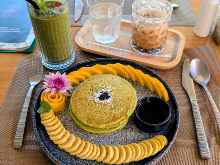 a stack of green pandan pancakes surrounded by banana slices at hey bong vegan restaurant in siem reap