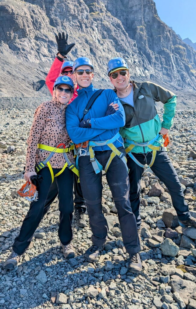 a group of three travelers posing just before a glacier hike in iceland