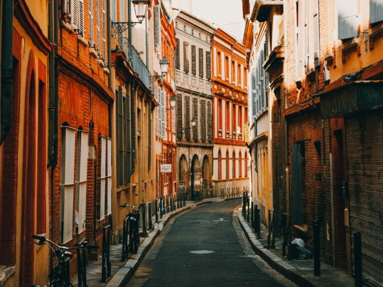 a narrow street with no cars and colorful building in toulouse france