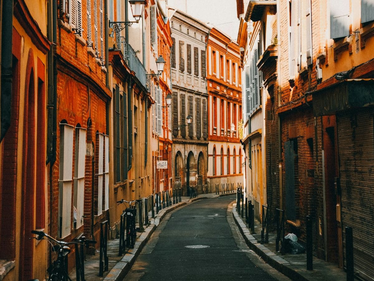a narrow street with no cars and colorful building in toulouse france