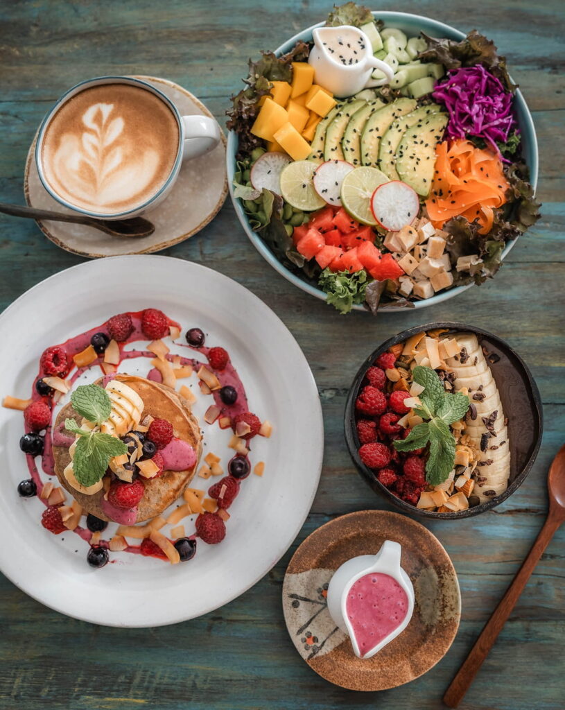 a beautiful spread of colorful vegan breakfast dishes covered in fresh fruit and mixed veggies at SOUL Vegan Cafe & Restaurant Phuket in phuket