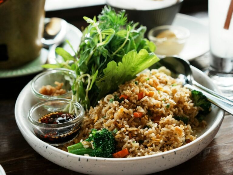 a large round bowl filled with vegan fried rice and leafy greens in krabi thailand