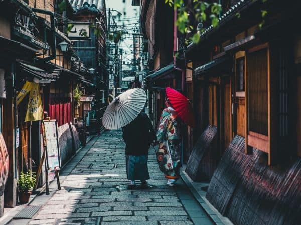 women walking through the old town of kyoto
