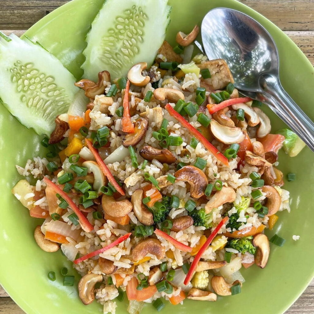 large green bowl filled with vegan fried rice with chunks of cashews at the thai restaurant colorful in Koh Phangan
