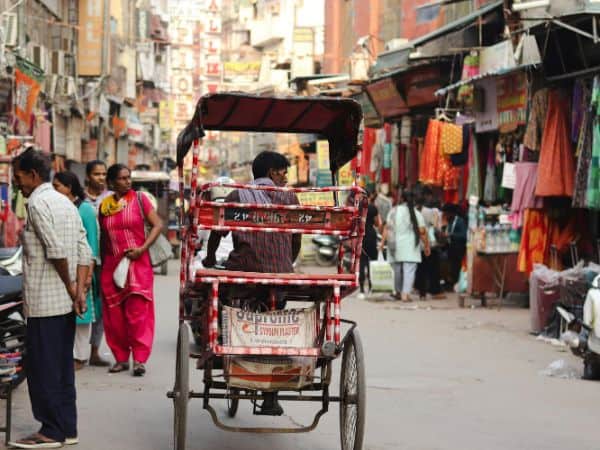 a single rickshaw driving down the street in delhi