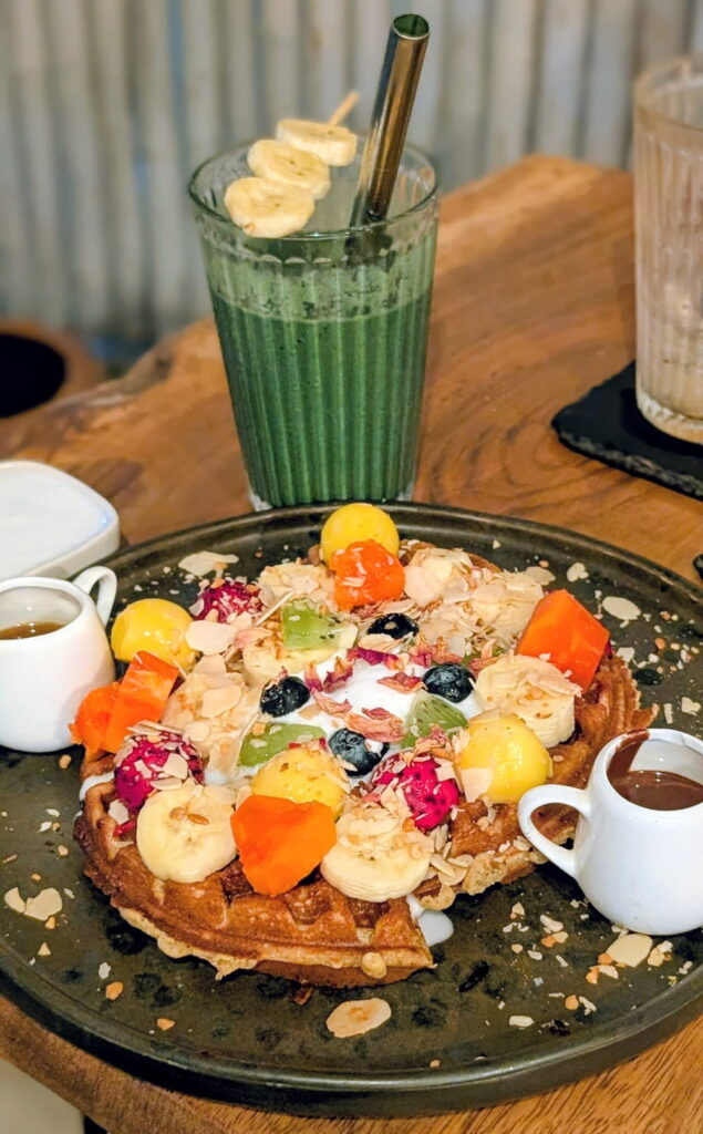 large golden belgian waffle topped with coconut cream and fresh fruit at eat.co in Koh Phangan