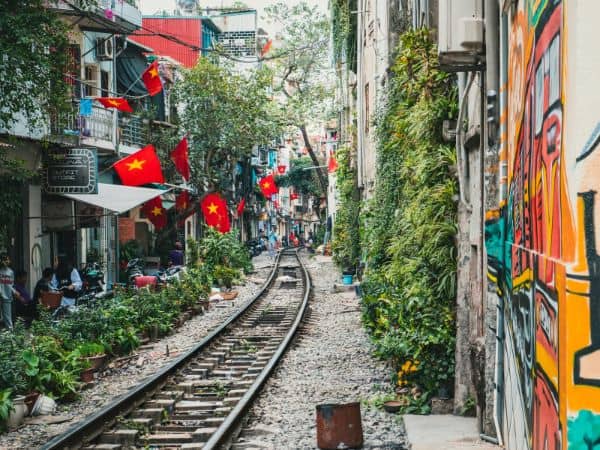the empty train tracks that run through train street in hanoi surrounded by little red vietnam flags