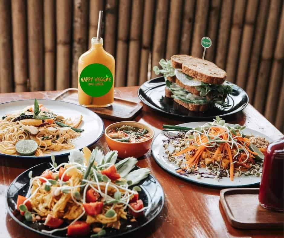 table filled with veagn thai dishes at happy veggie in koh lanta