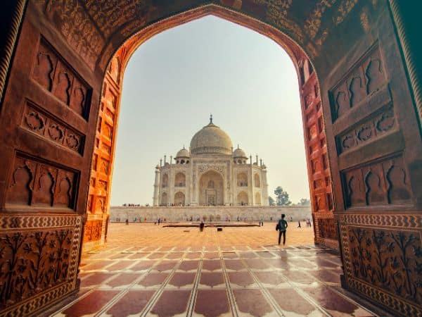 the taj mahal in the distance seen from the opening through a door