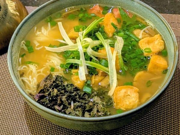 a large bowl of vegan pho with a light yello broth in hanoi