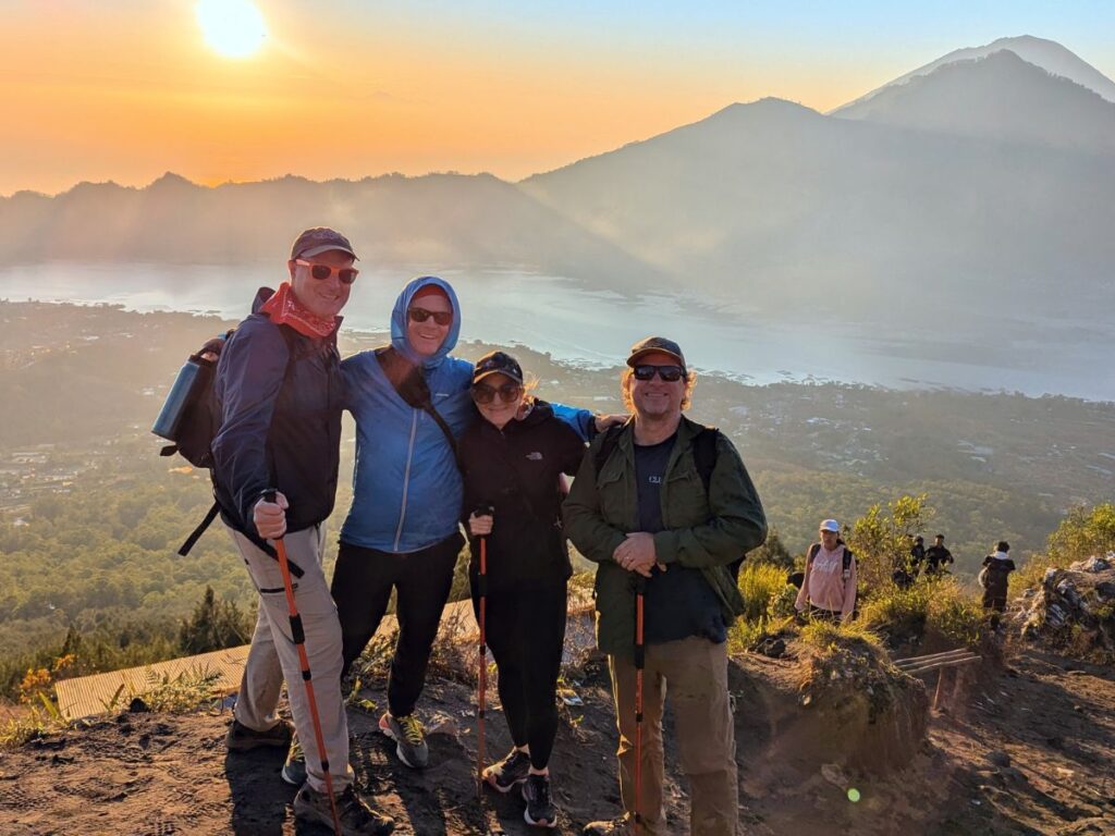 group of travelers at the top of a mountain just as the sun is rising during a vegan tour to bali