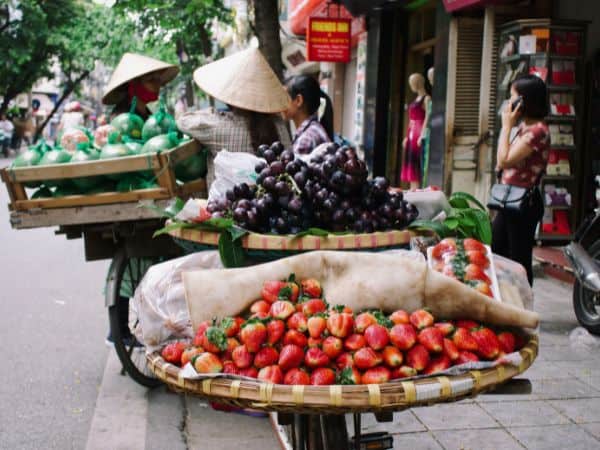 two large baskets of strawberries and other fruit on the back of a bike in vietnam