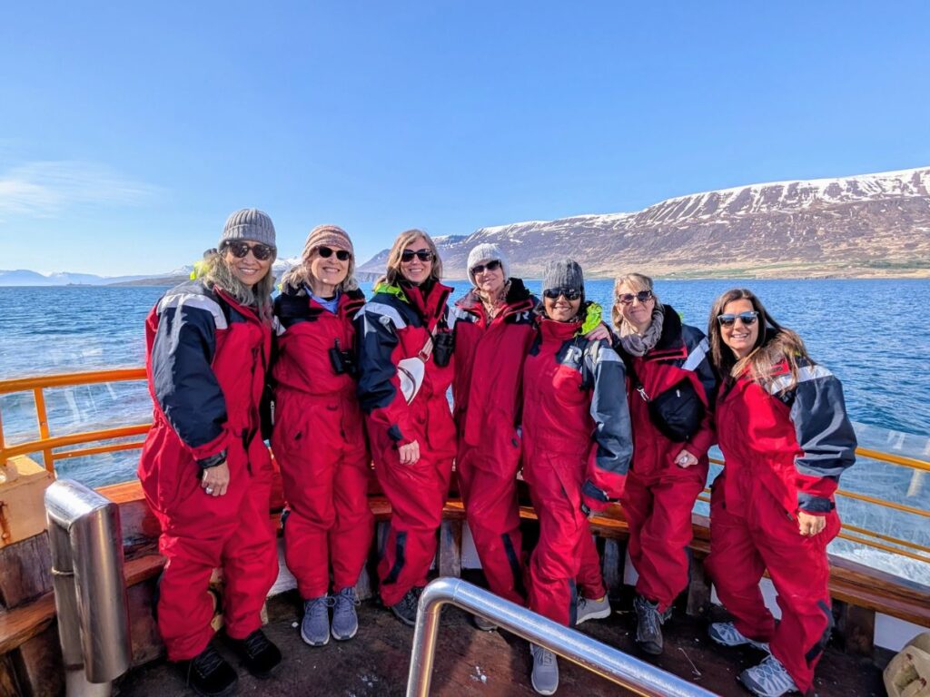 group of women standing together on a boat in iceland during a veggies about vegan tour