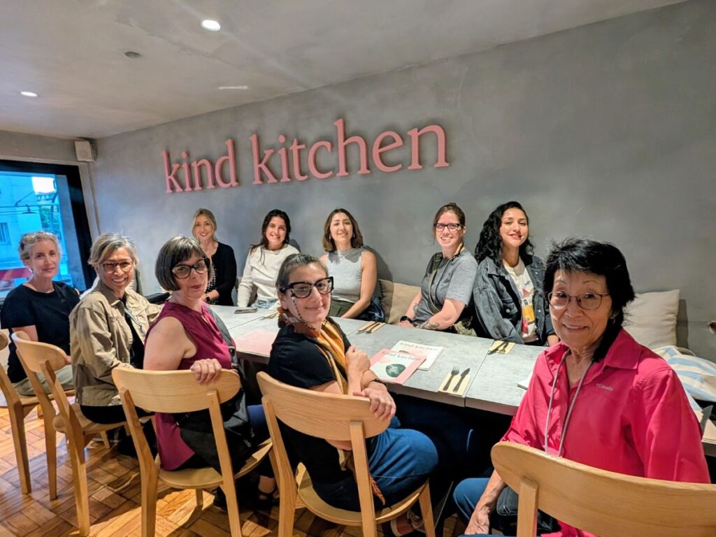 a group of women gathered around a table at the kind restaurant in porto Portugal during a veggies about vegan tour