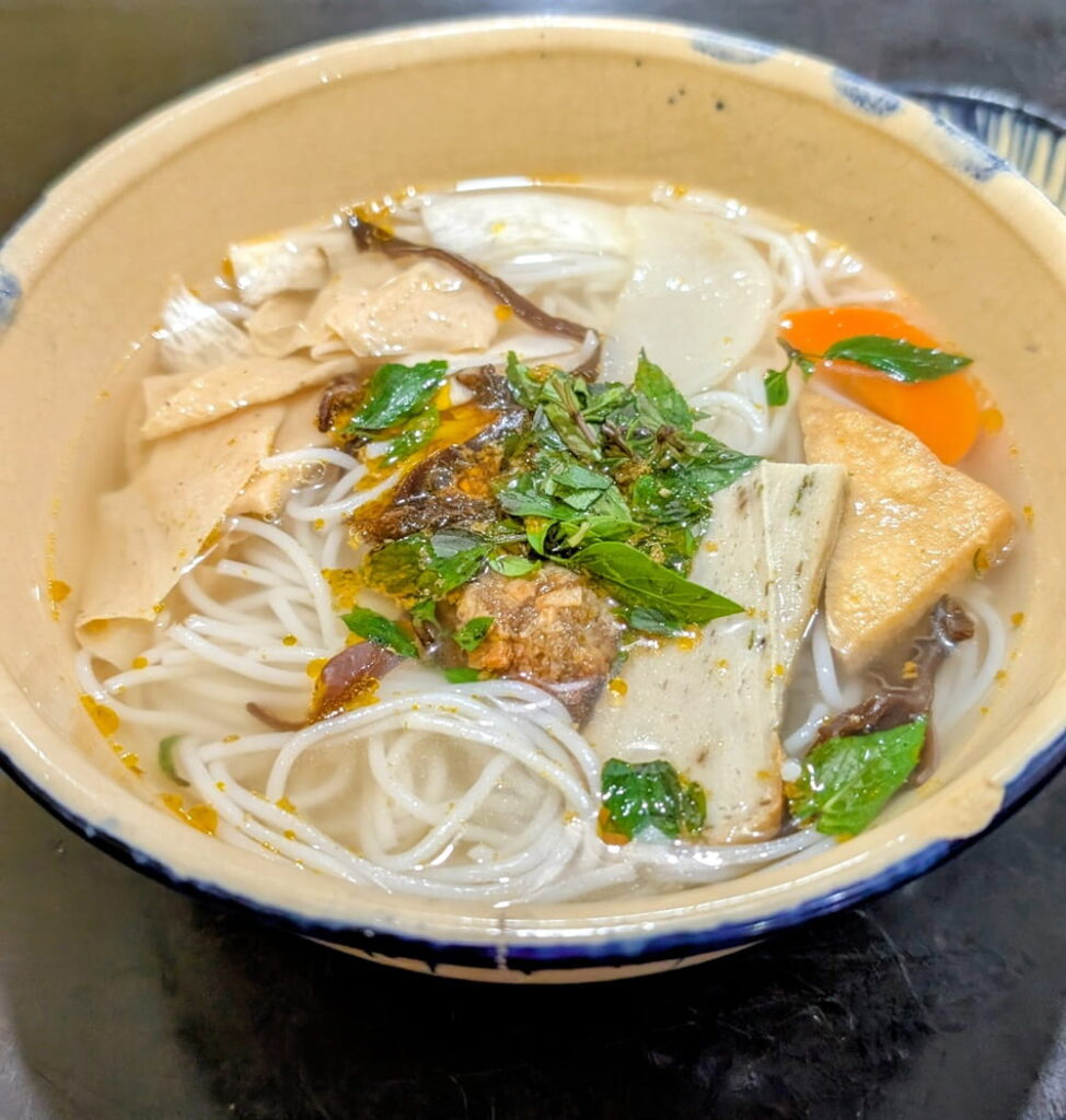 a large bowl of vegan tofu noodle soup at Mộc Lâm An Vegan in hoi an