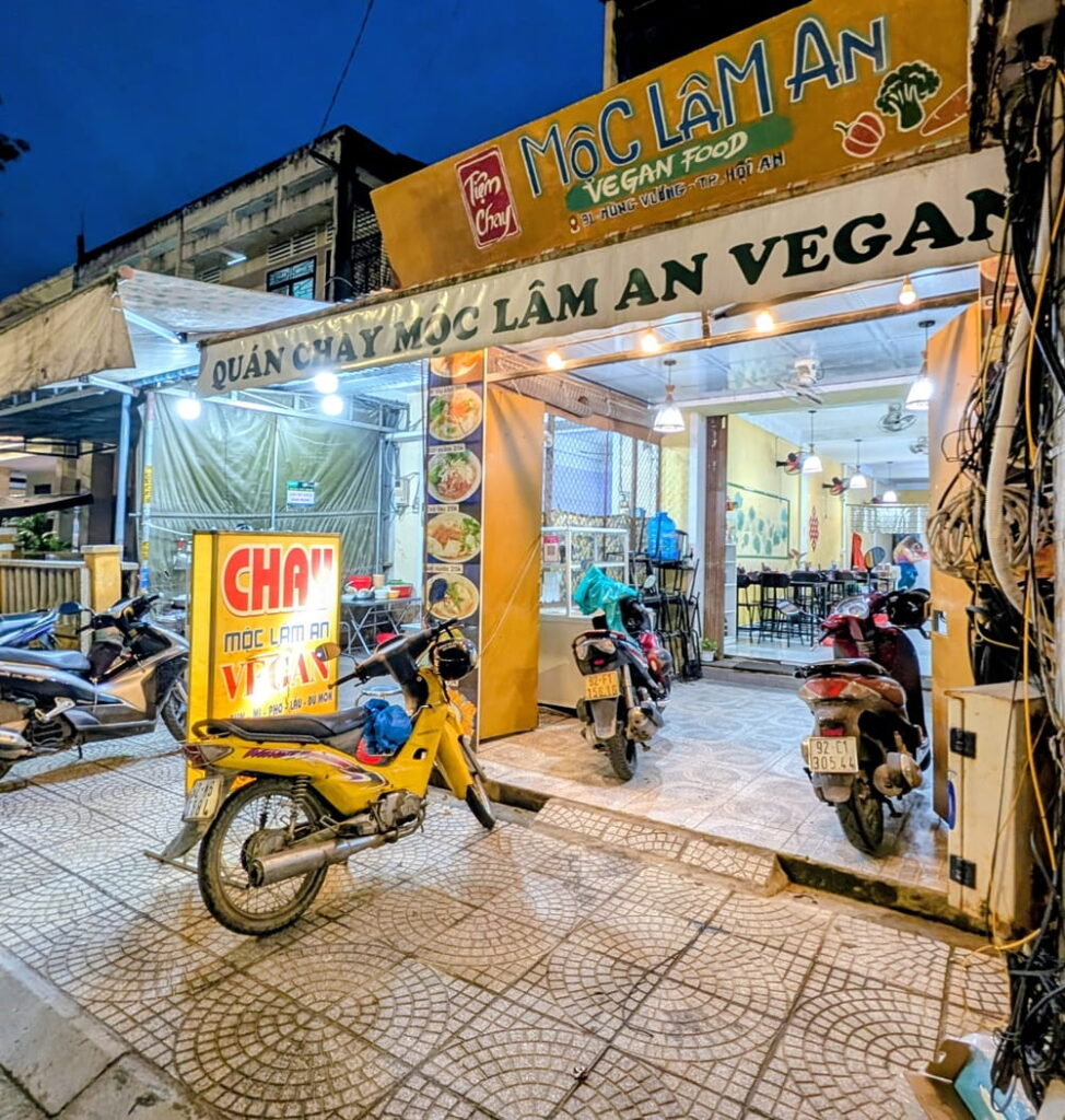 the yellow painted outside entrance to Mộc Lâm An Vegan with a motorbike parked in front