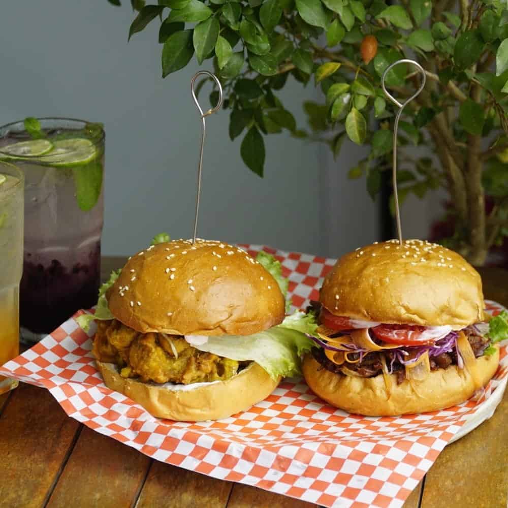 two vegan hamburgers on a red and white checkered paper at kiez in hanoi