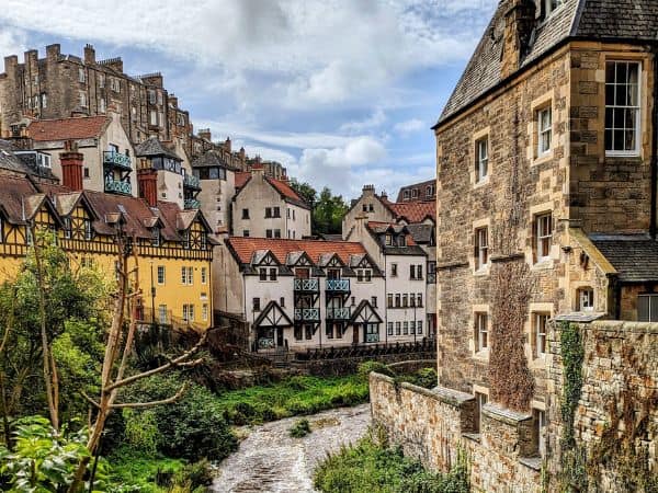 a small charming scottish village with a river running through it on a bright day in scotland