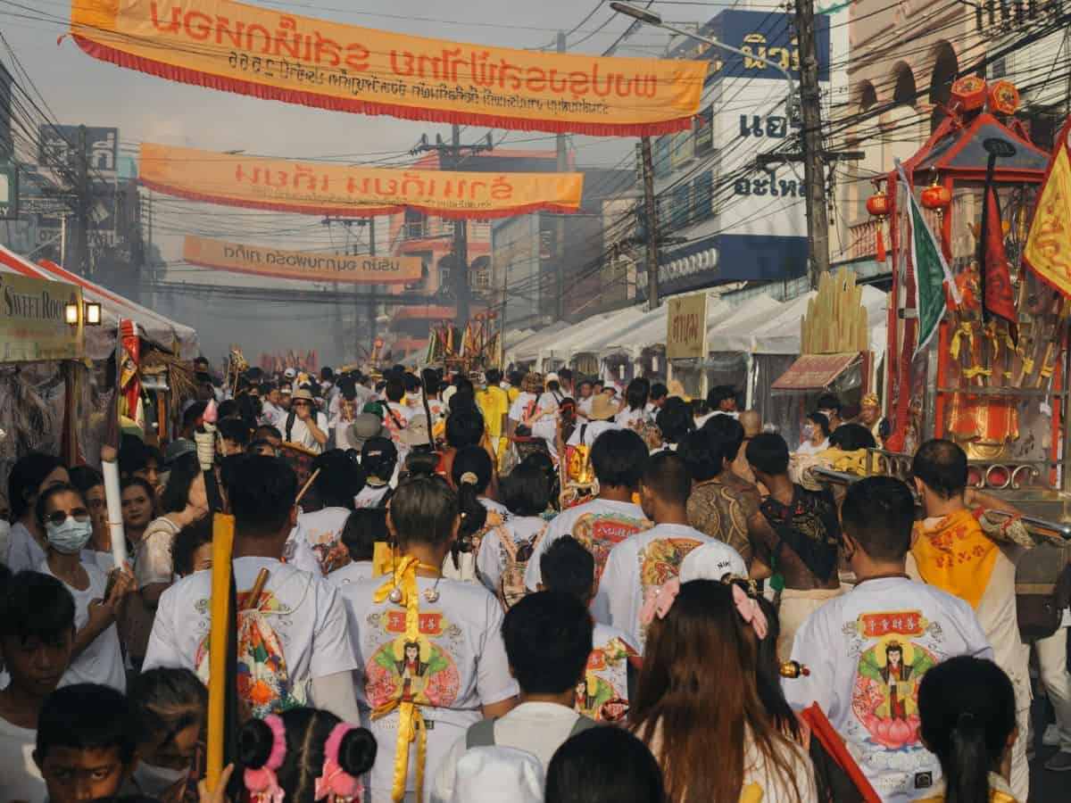 street full of people celebrating the vegetarian festival in thailand