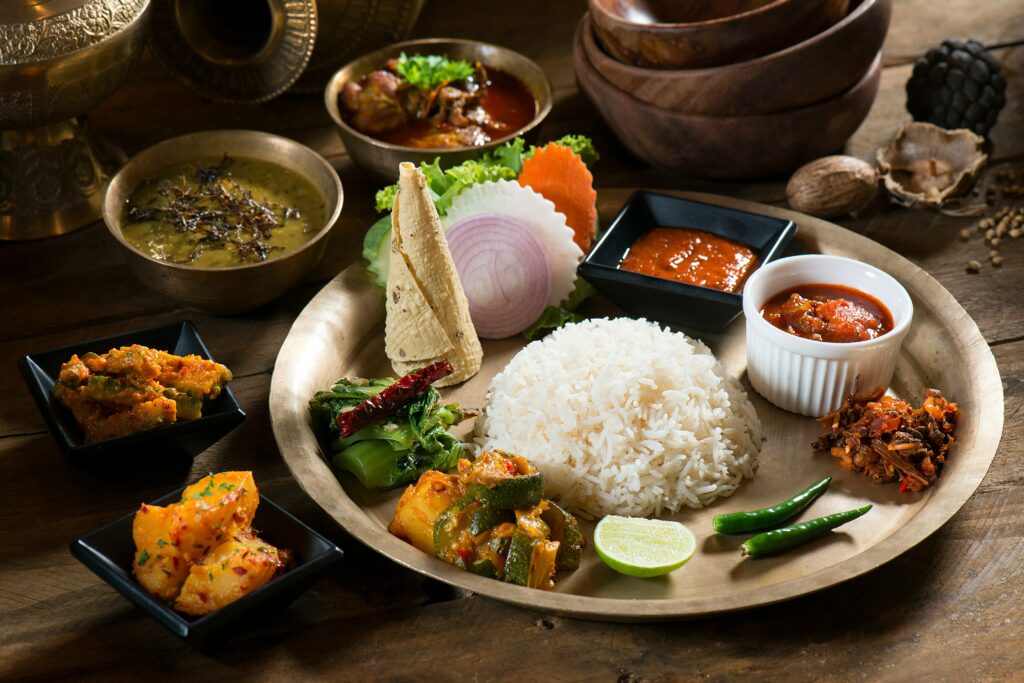 Traditional North Indian thali with rice, vegetable curries, dal, pickles, and fresh vegetables.