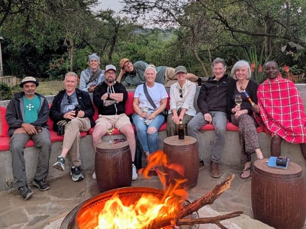group of veggies abroad travelers in front of a fire pit in the maasai mara during a vegan tour