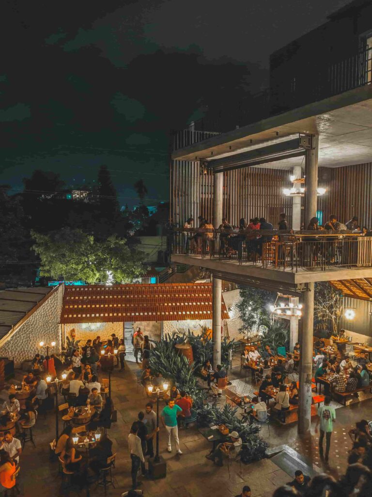 Outdoor rooftop restaurant and beer garden in Bengaluru, India, filled with diners enjoying the city's vibrant nightlife.