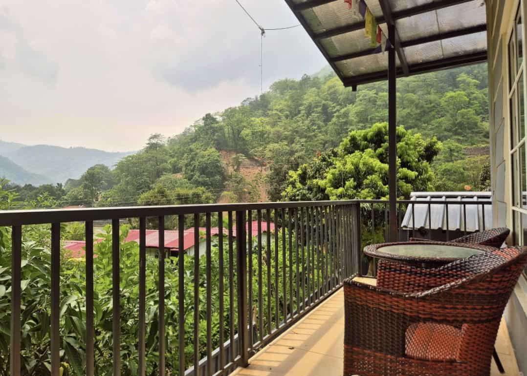 Balcony at Bunk Stay in Rishikesh overlooking the lush green Himalayan foothills