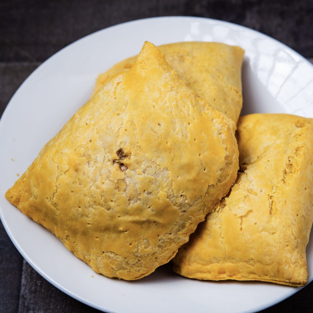 Traditional Jamaican vegetable patties served on a white plate.