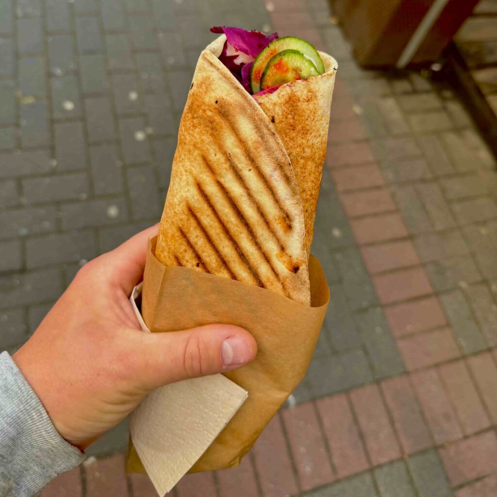 Vegan kebab wrap filled with fresh vegetables and pickled toppings.