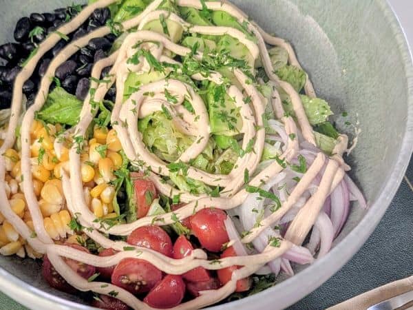 a colorful vegan salad bowl with a swirl of vegan dressing in kigal rwada