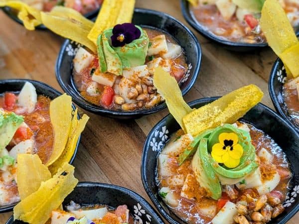 multiple little bowls of vegan ceviche with strips of plantain sticking out