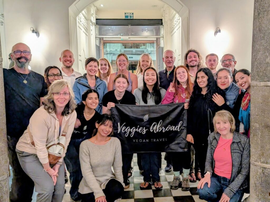 a group of 16 people traveling with the vegan travel company veggies abroad in a hotel lobby after a dinner hosted by quinti travel