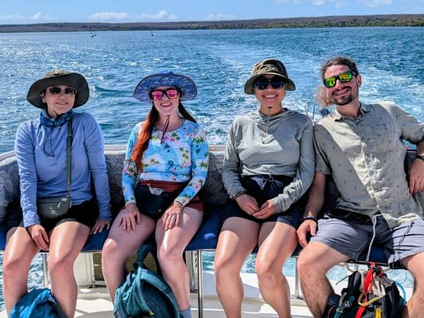 four vegan travelers on a boat during a ride to an island during a veggies aborad vegan galapagos tour